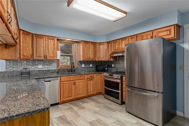 kitchen featuring tasteful backsplash, sink, appliances with stainless steel finishes, and dark stone counters