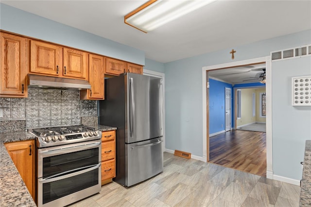 kitchen featuring backsplash, stainless steel appliances, ceiling fan, light hardwood / wood-style flooring, and dark stone countertops