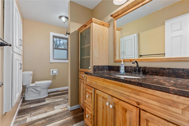 bathroom featuring toilet, vanity, and hardwood / wood-style flooring