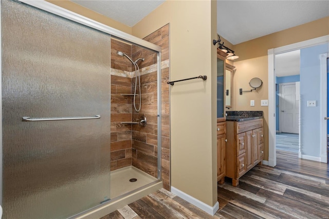 bathroom featuring vanity, an enclosed shower, and hardwood / wood-style flooring