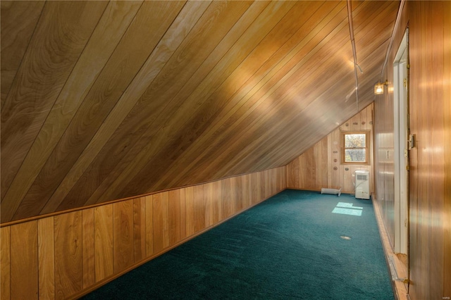 additional living space with wood walls, wooden ceiling, vaulted ceiling, and dark colored carpet