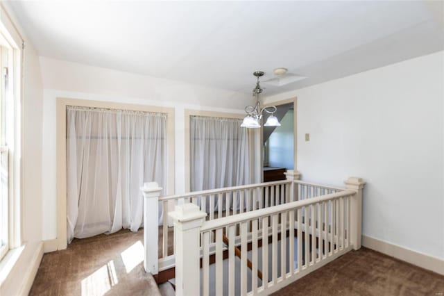 carpeted bedroom with a notable chandelier and a nursery area