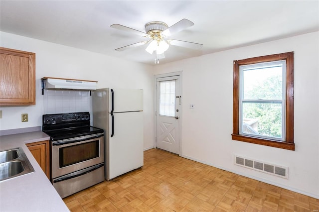 kitchen featuring sink, stainless steel range with electric stovetop, white fridge, ceiling fan, and light parquet flooring