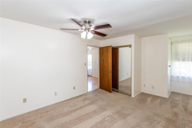 unfurnished bedroom featuring light colored carpet, ceiling fan, and a closet