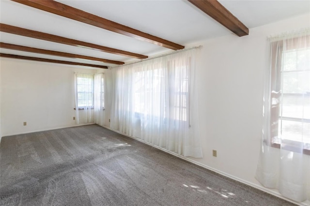 carpeted empty room with beamed ceiling