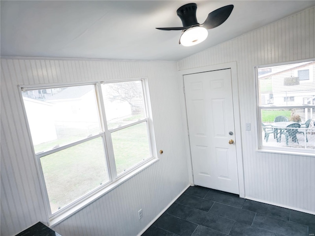 tiled entryway featuring plenty of natural light, ceiling fan, and vaulted ceiling