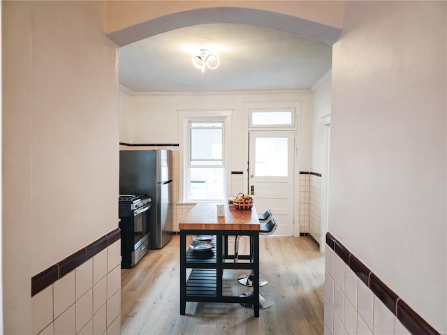 dining room with tile walls and light hardwood / wood-style flooring