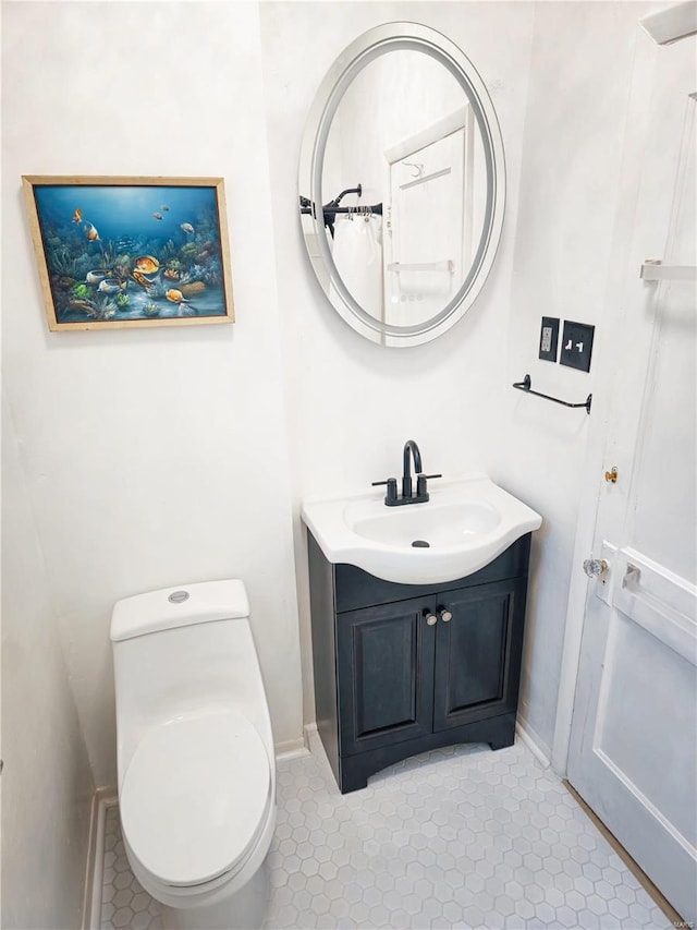 bathroom featuring vanity, tile patterned floors, and toilet