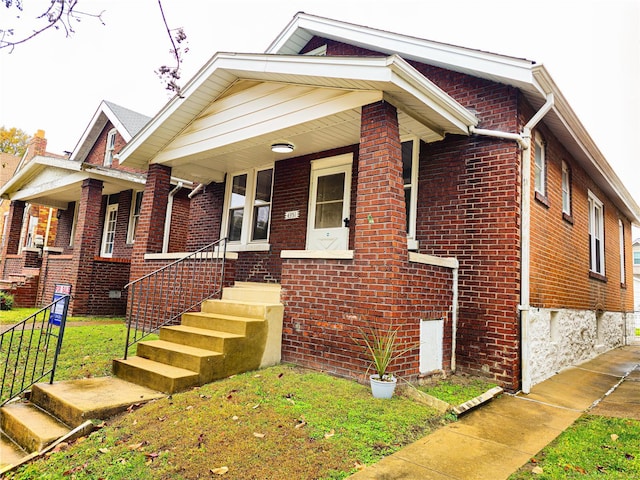 view of front of house with a porch and a front yard