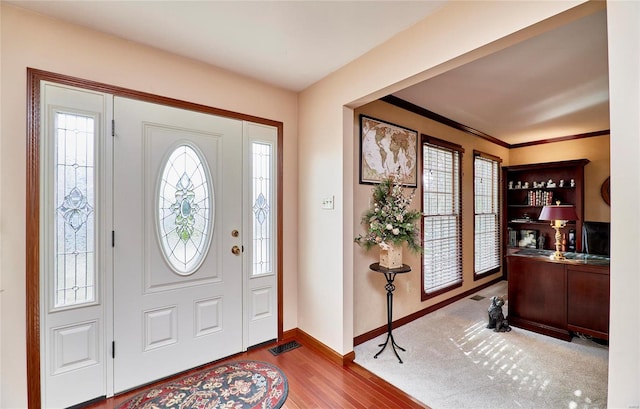 foyer entrance featuring hardwood / wood-style flooring and ornamental molding