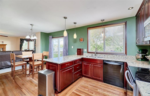 kitchen with light wood-type flooring, black dishwasher, a wealth of natural light, and an inviting chandelier