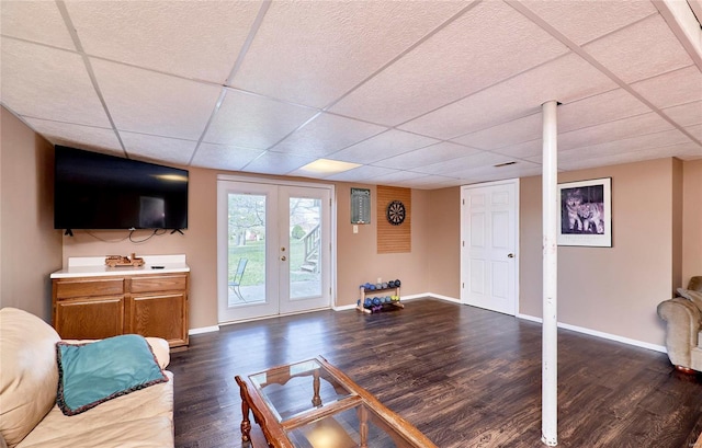 living room with a paneled ceiling, dark hardwood / wood-style flooring, and french doors