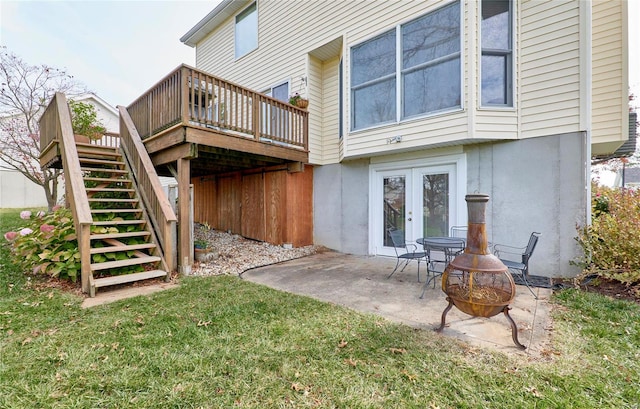 back of house with a lawn, french doors, a wooden deck, a patio area, and an outdoor fire pit