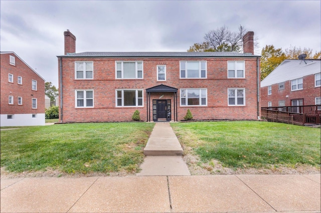 view of front facade featuring a front yard and a wooden deck