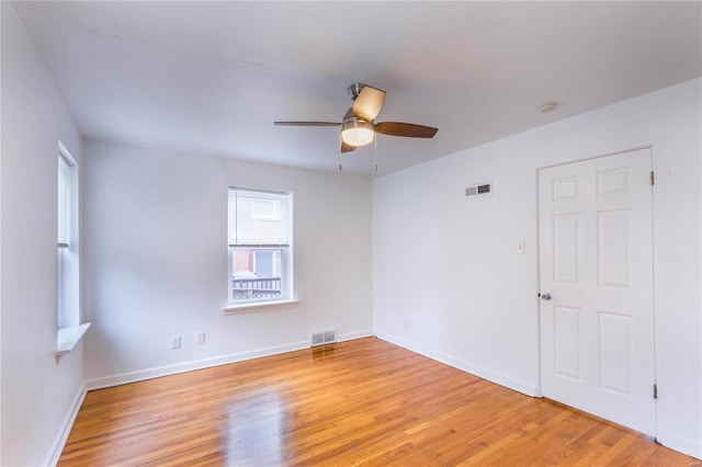 empty room with ceiling fan and light hardwood / wood-style floors