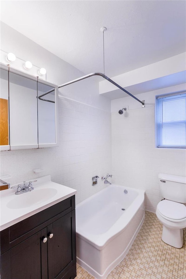 full bathroom featuring tile walls, vanity, toilet, and tiled shower / bath