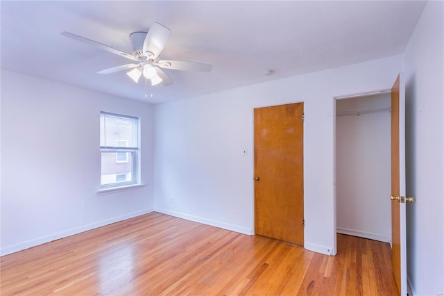 unfurnished bedroom with ceiling fan, a closet, and light wood-type flooring