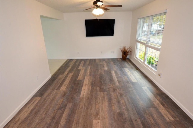 empty room featuring dark wood-type flooring and ceiling fan