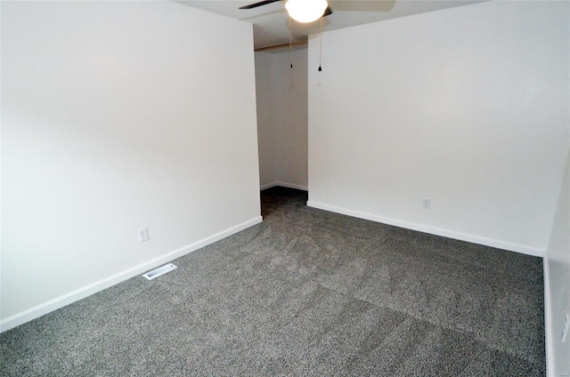 spare room featuring ceiling fan and dark colored carpet