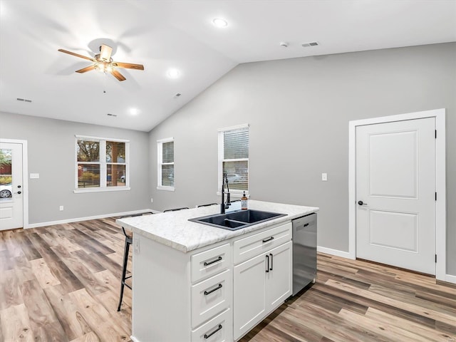 kitchen featuring dishwasher, a center island with sink, white cabinets, sink, and light hardwood / wood-style flooring