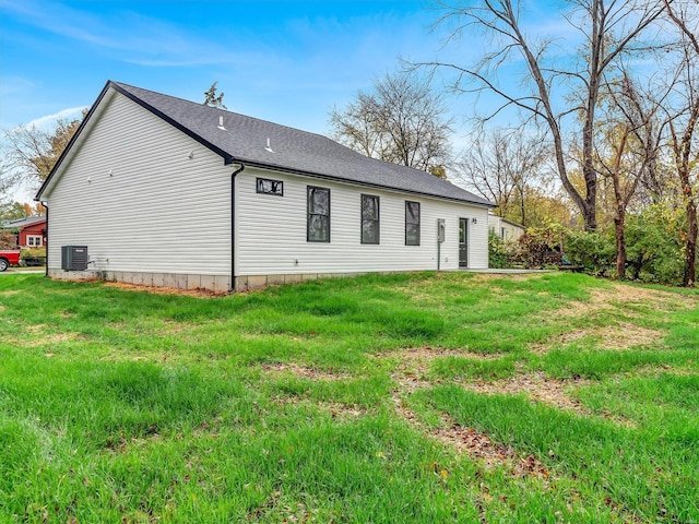 view of side of property with a lawn and central AC