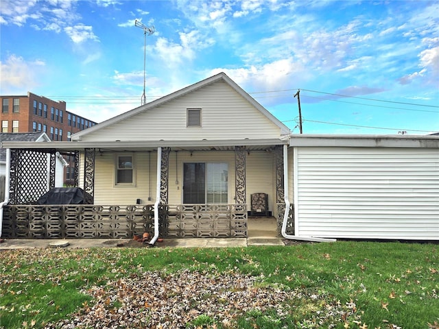 back of property with a porch and a lawn