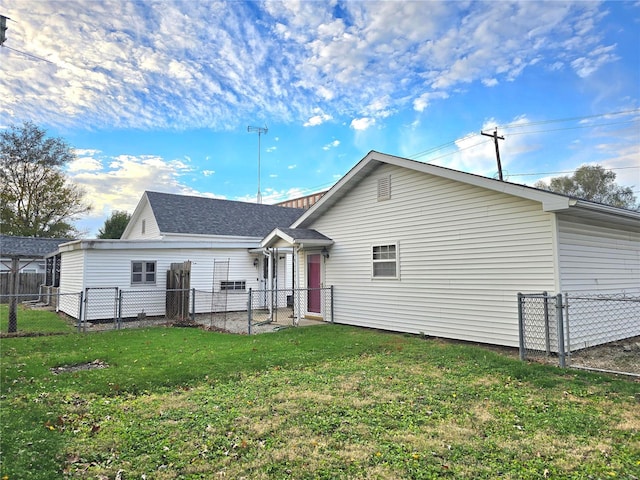 rear view of house featuring a lawn