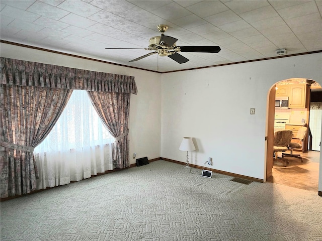 carpeted empty room featuring ceiling fan and ornamental molding