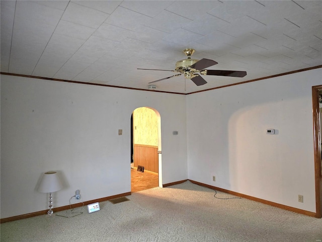 empty room featuring light carpet, ceiling fan, and ornamental molding