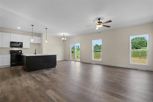 kitchen featuring white cabinetry, black appliances, dark hardwood / wood-style floors, hanging light fixtures, and a kitchen island with sink