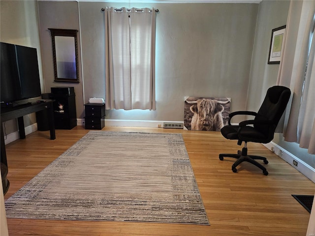 home office with light hardwood / wood-style floors