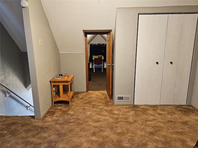 carpeted bedroom with lofted ceiling and a closet