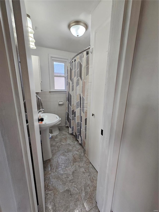 bathroom featuring walk in shower and tile walls