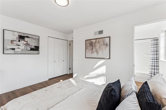 bedroom with dark hardwood / wood-style flooring and ensuite bath