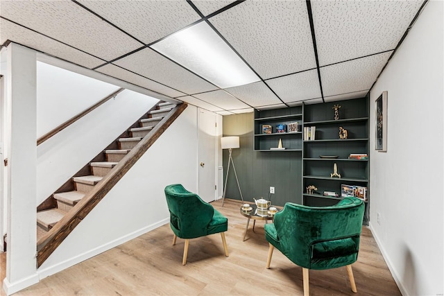 sitting room with a paneled ceiling and hardwood / wood-style flooring