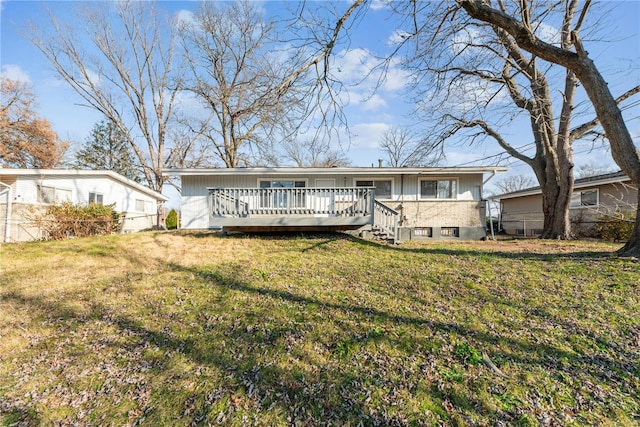 rear view of house with a deck and a yard