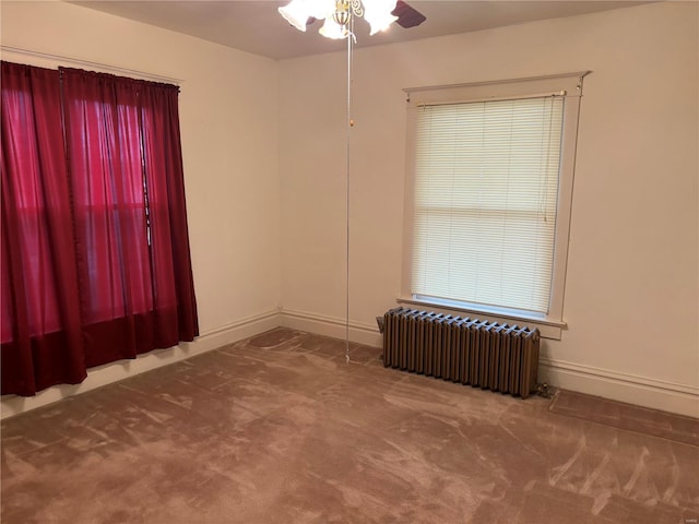 empty room with carpet flooring, radiator, and ceiling fan