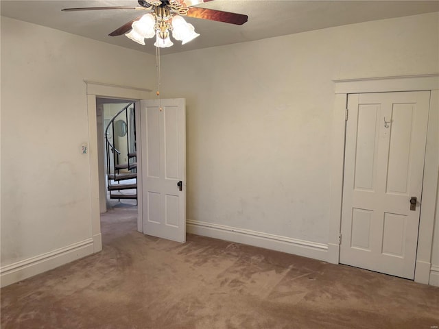 carpeted empty room featuring ceiling fan