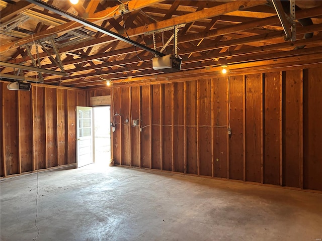 garage featuring a garage door opener and wood walls