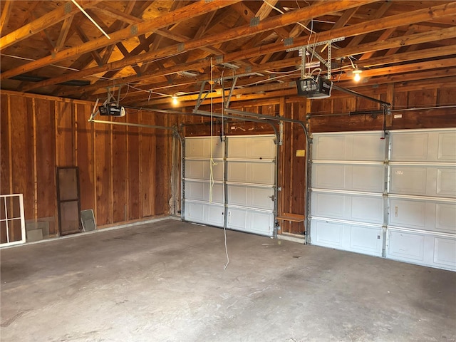 garage featuring wood walls and a garage door opener