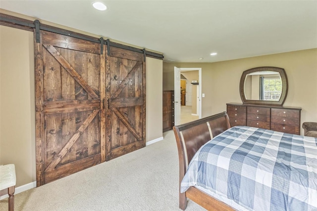 carpeted bedroom featuring a barn door