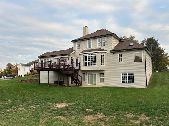 rear view of property featuring a yard and a deck