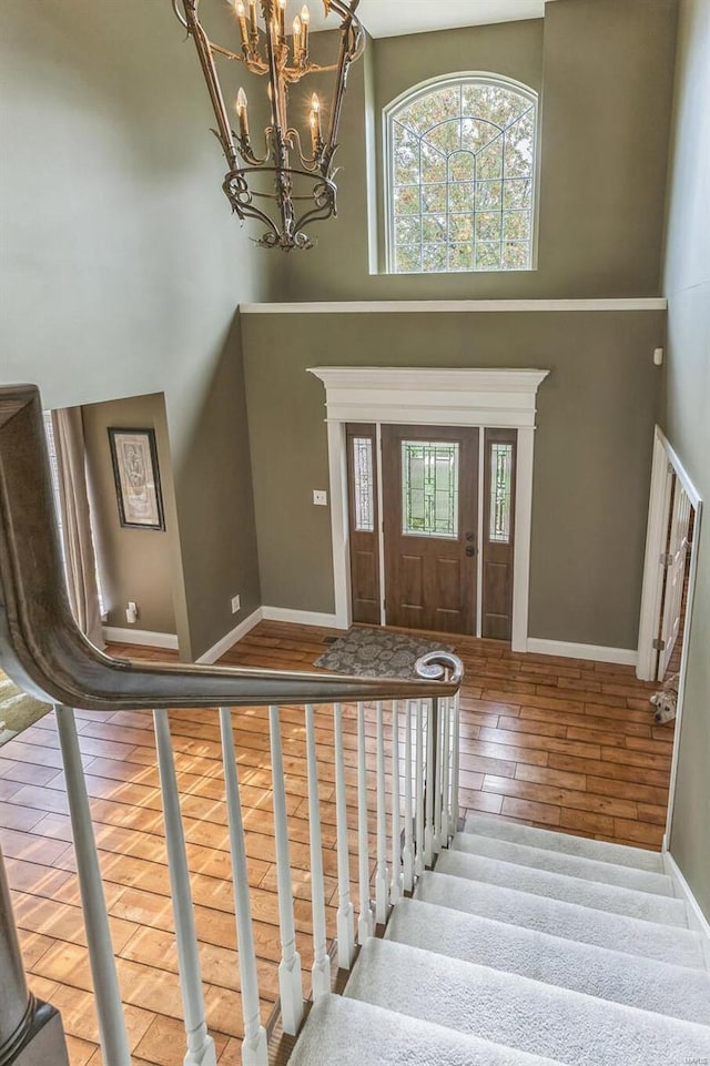 foyer entrance featuring hardwood / wood-style floors and a towering ceiling