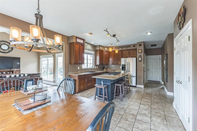 kitchen with tasteful backsplash, a center island, pendant lighting, and appliances with stainless steel finishes