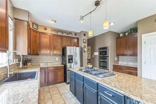 kitchen featuring pendant lighting, backsplash, sink, appliances with stainless steel finishes, and light stone counters