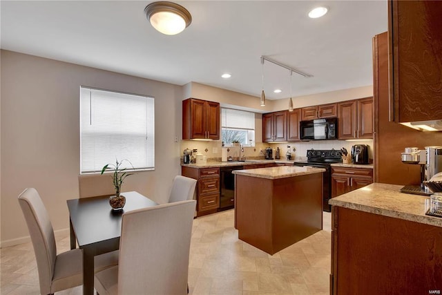 kitchen featuring black appliances, light stone counters, a kitchen island, hanging light fixtures, and sink