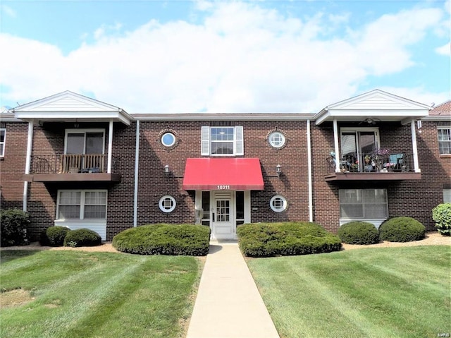 multi unit property with a front lawn and a balcony