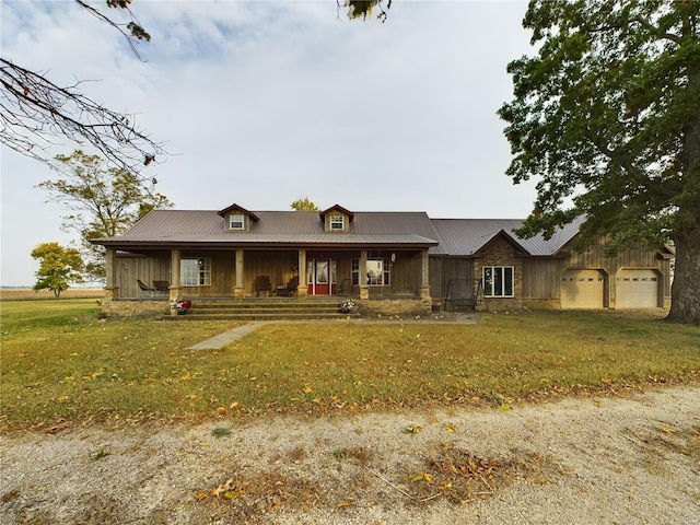 view of front of home with covered porch, a front yard, and a garage