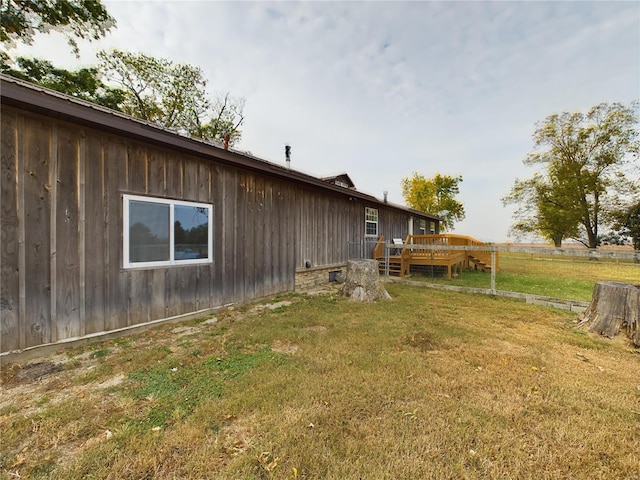 view of property exterior featuring a deck and a lawn