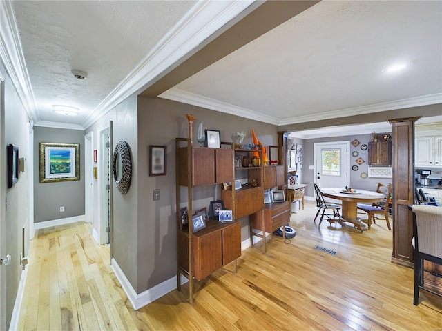 hallway featuring ornate columns, light hardwood / wood-style floors, and ornamental molding